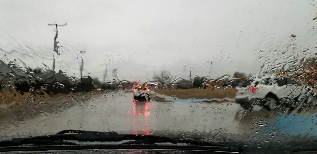 Rain-soaked road seen through a windshield, the kind of weather hurricane car prep in Davie, FL is meant for