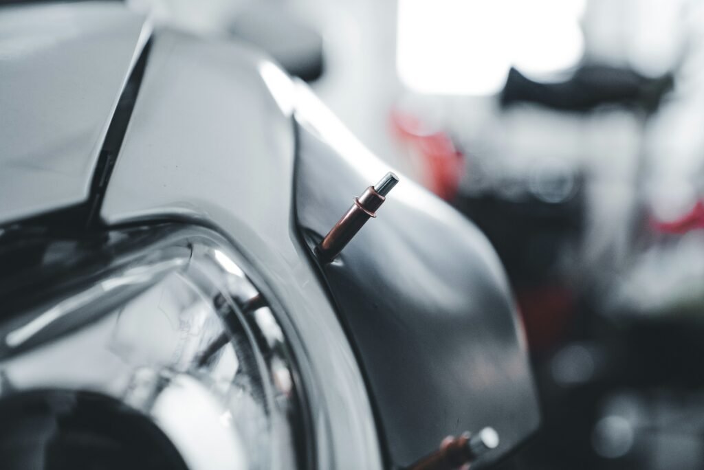 Technician spot welding a car body panel during auto body and paint work in Fort Lauderdale