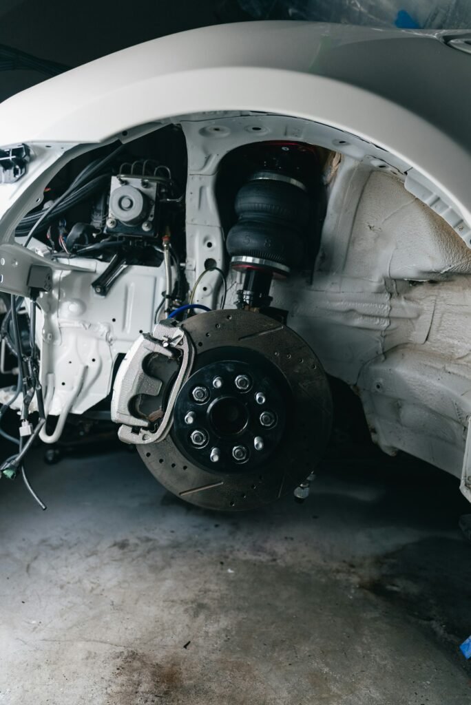 Disassembled front suspension and wheel assembly on a car during suspension repair in Weston, FL